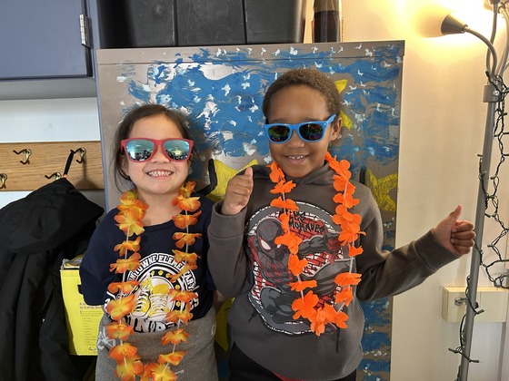 two students wearing leis and sunglasses