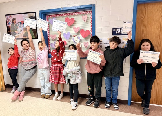students holding up certificates