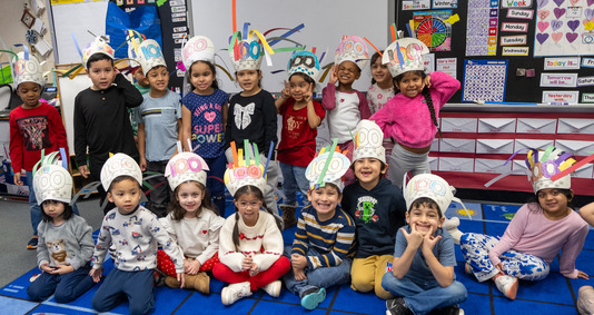 A group of kindergarten students, wearing 100th day of school hats