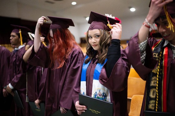student smiling as they move their tassel on graduation day