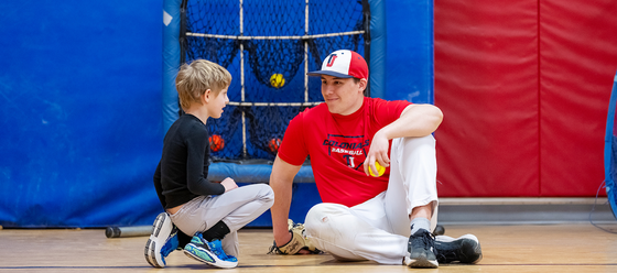 baseball player smiles at an elementary school student
