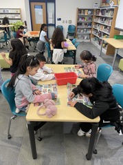 Group of students looking through Book Fair catalogs.