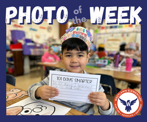 Photo of the Week: a student holds up his writing. It says "In 101 days I learned how to read books."
