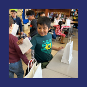 a student smiles as he receives a card from a peer