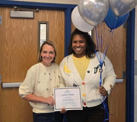 Two staff members holding balloons
