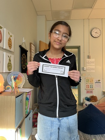 A student holds a "caught being kind" ticket 