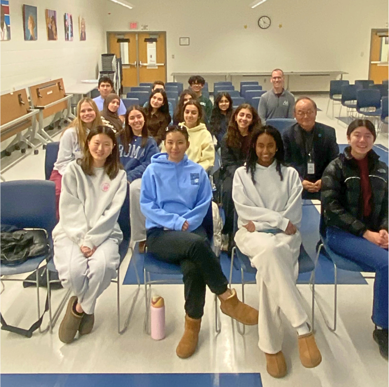 Members of the Marshall High School DECA club are sitting in chairs 