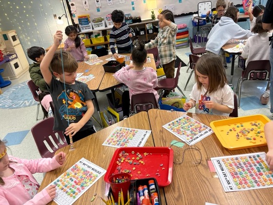 Students stringing 100 cereal rings 