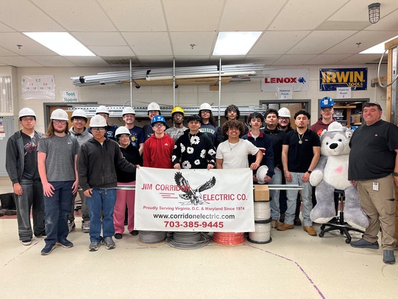students holding corridon electric banner