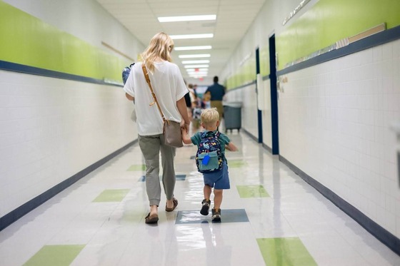 parent and child walking together in a school hallway