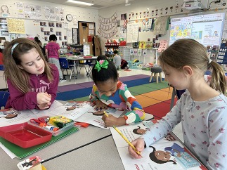 3 girls working at a table in class