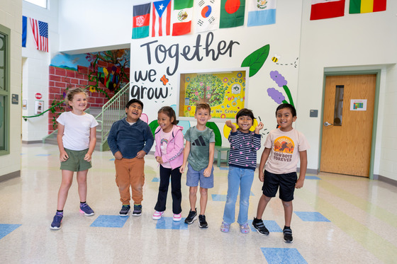 A group of students stand in the front lobby