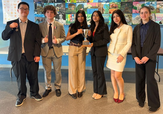 Woodson Debate team posing with 2nd place regional trophy
