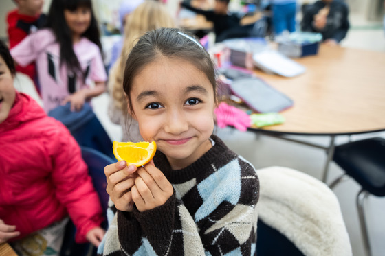 photo of girl holding an orange slice