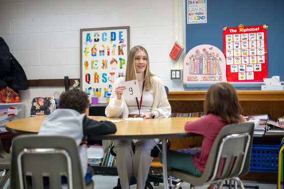 Teacher holds up a letter to work with students on literacy