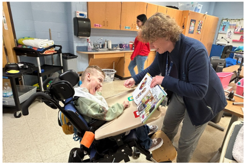 Key Center Celebrated Read Across America Day - Ann Smith showing the pictures in the book to student