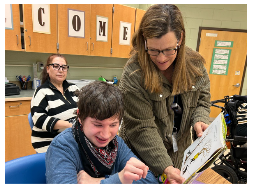 Key Center Celebrated Read Across America Day - Emily K holding a book and reading to a student