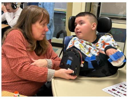 Celebrating Black History with Bingo Fun!- a teacher holding a device for student to communicate