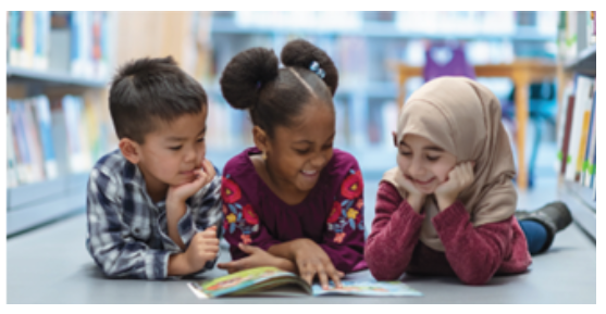 Reading Opens the World Book Drive and Family Literacy Fair-picture showing 3 young students looking a book