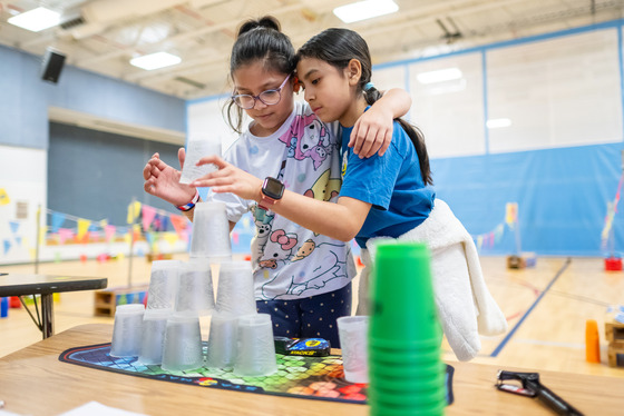 two students stacking cups together in gym class