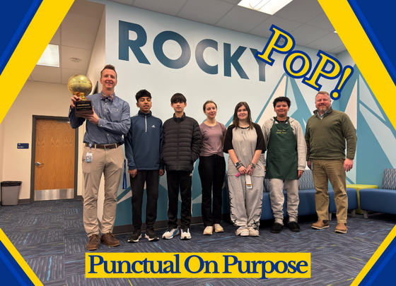 Weekly Punctual on Purpose winners standing with Mr. Kownacki and Mr. Smith, holding a basketball trophy