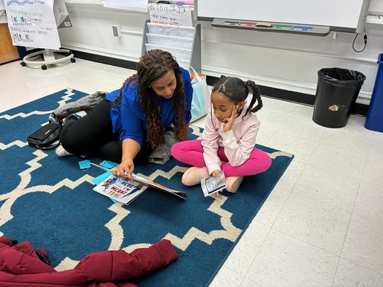 An adult and a child reading together at Family Learning Night