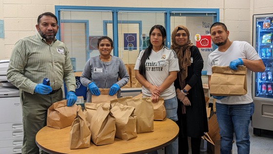 A group of parents, holding bags, organizing Fresh Pack
