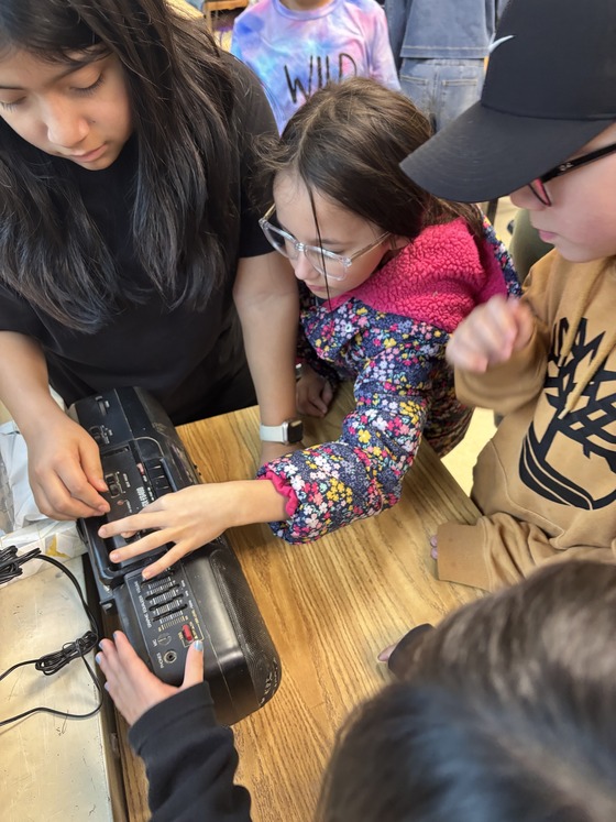 3rd graders trying to work the radio on an old boom box