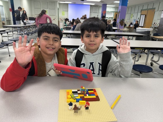 Two boys are building with legos and using the iPad to record 