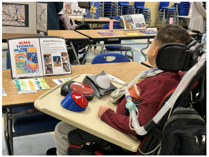 Student looking at his art