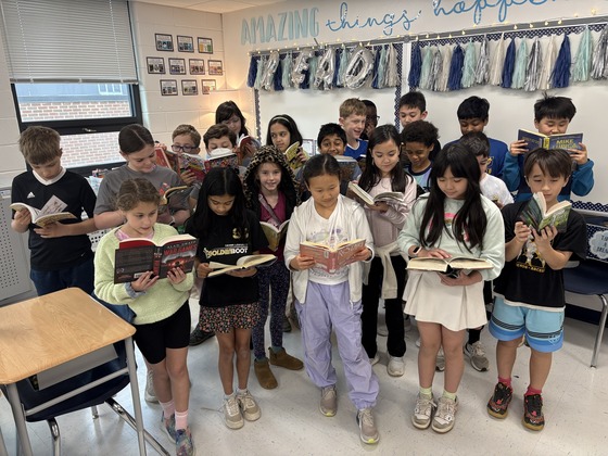 4th grade class posing while reading books