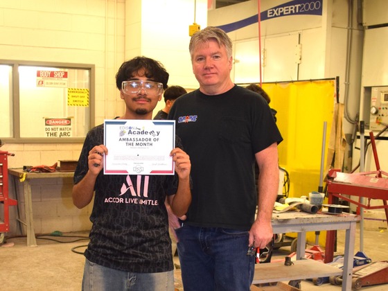 student and teacher posing with award