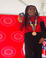 student smiling with medal