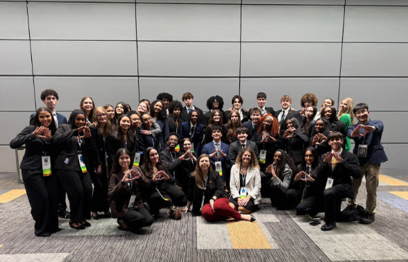 group of students and two adult sponsors, in business attire
