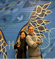 staff member and student standing back to back 