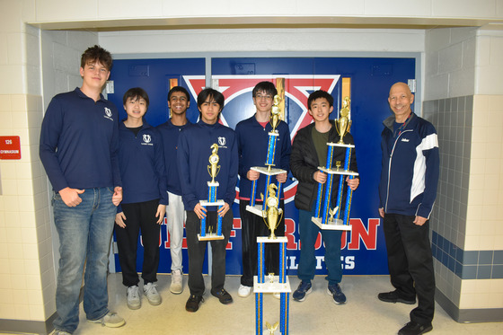 TJ's Under-1400 Chess Team poses with state title in front of gym door.