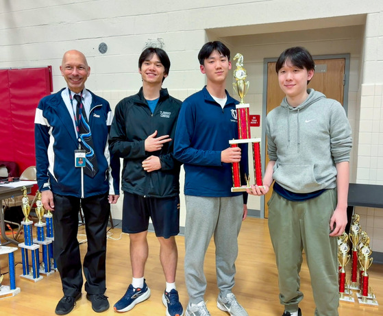 TJ's Blitz Chess Team posing with state title in cafeteria.
