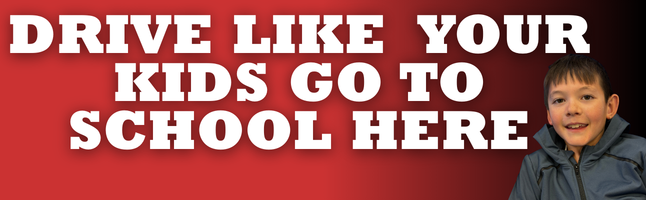 Red & black gradient with boy smiling with 'Drive like your kids go to school here' in white writing