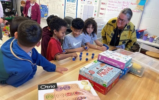 Dr. Reid smiles as she watches students play a game