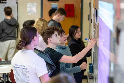 student writing on a white board