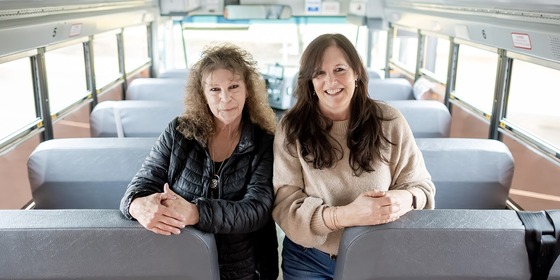 Paula and Pam smile for a photo on their bus