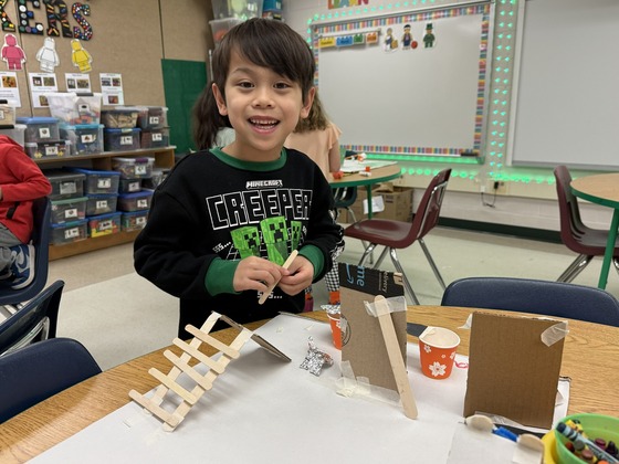 Student in STEAM lab working with recycled matierals to build a playground. 