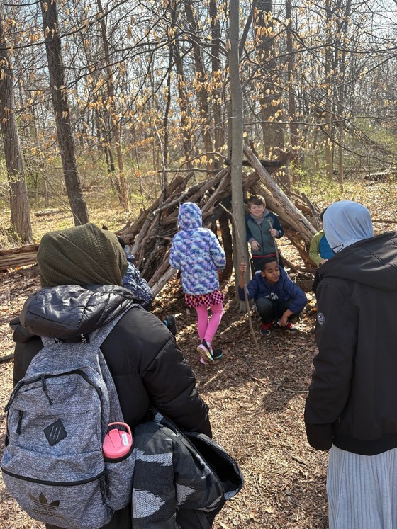 students exploring a fort of sticks
