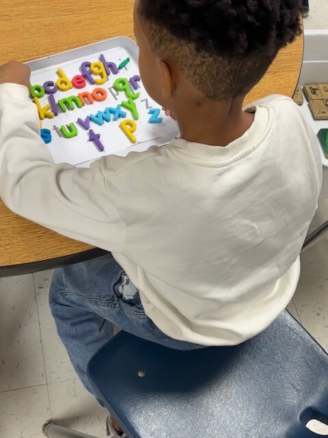 Student with Magnetic Letter Tiles