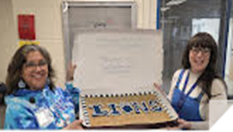 Ladies holding a cake