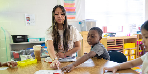 A teacher and student work at a table
