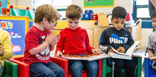 Pre-schoolers sitting and reading 