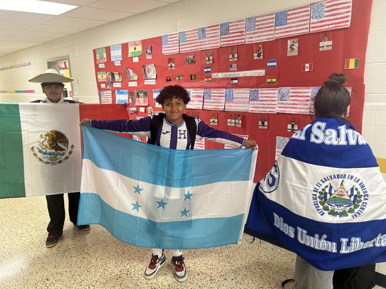 Students displaying flags that represent their families' cultures.
