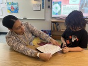 Teacher helping a student cut