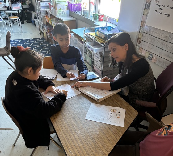A teacher works a table with two students 